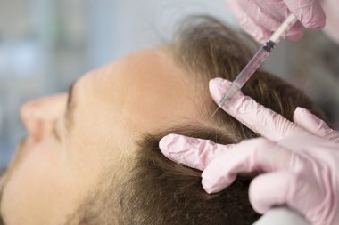 Güzellik closeup ana yapıyor enjeksiyon In genç erkek hasta Face. Güzellik yordamı kullanarak dolgu enjeksiyonları almak adam. Kozmetik ve Güzellik yüz enjeksiyon kavramı