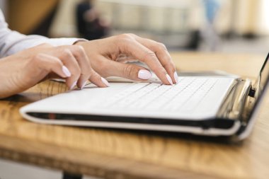 Kafeterya masada oturan bir dizüstü bilgisayar klavye sıcak güneşli bir gün açık havada, içinde yazarak kadın. Metin için yer.