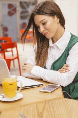 Bir yaz teras kafede bir freelancer olarak çalışan esmer iş kadın. Onun iş için çay ve kullanım araçları dizüstü ve tablet ve telefon gibi içiyor. Metin için yer.