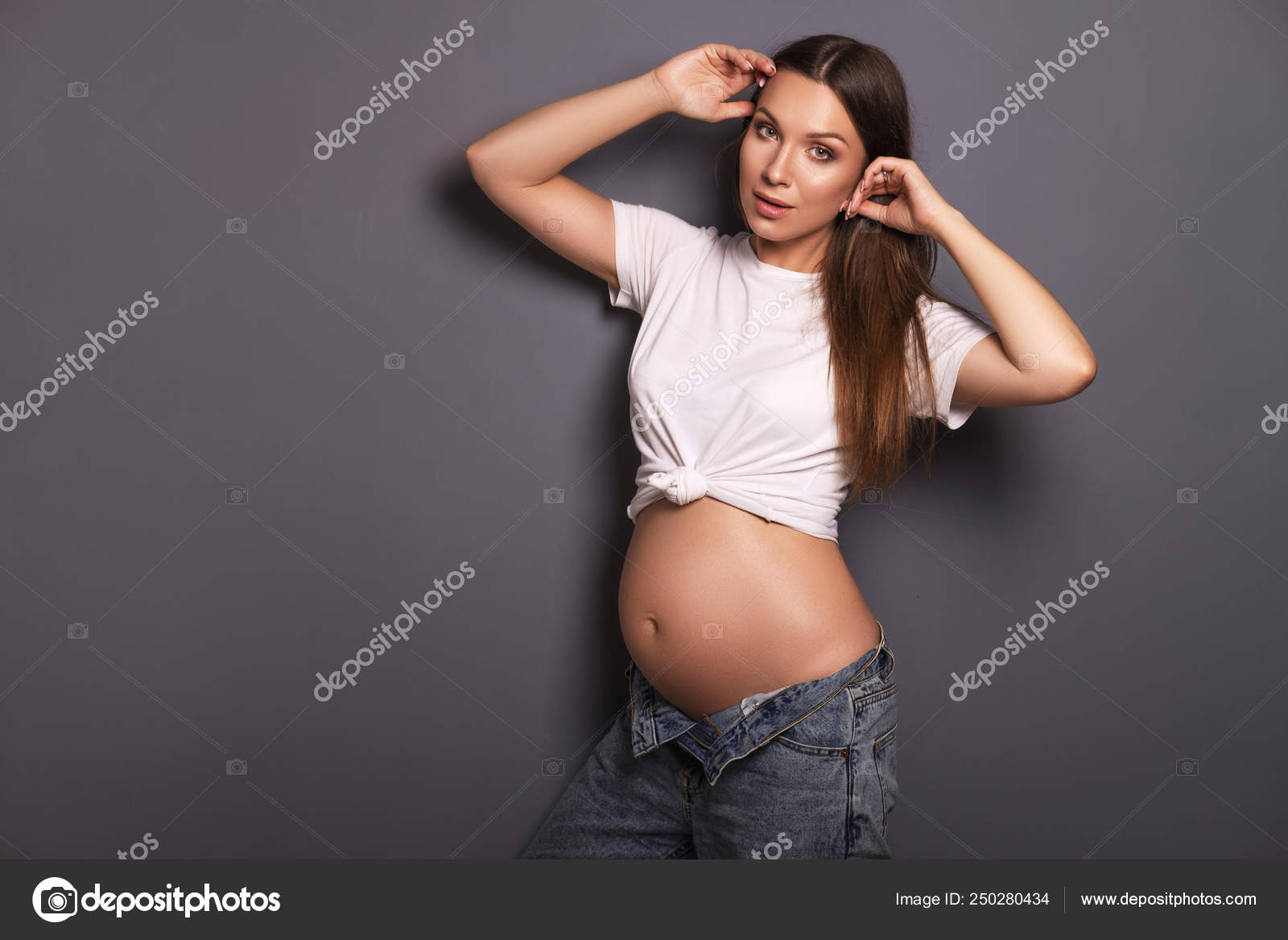 Sexy brunette pregnant woman with long hair and in jeans and whi Stock  Photo by ©Annademy 250280434