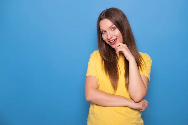 Linda mujer morena con el pelo largo posando en camiseta amarilla en una —  Fotos de Stock