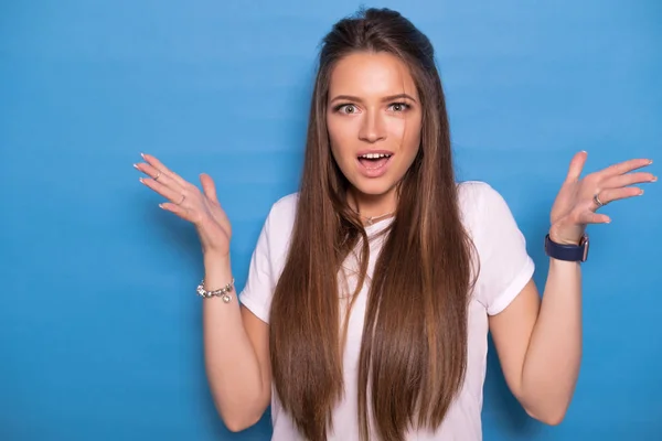 Söt brunett kvinna med långt hår poserar i vit t-shirt på en — Stockfoto