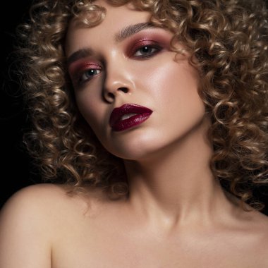 Koyu bir backg üzerinde afro (bukleler) saç modeli ile sevimli kafkas kadın