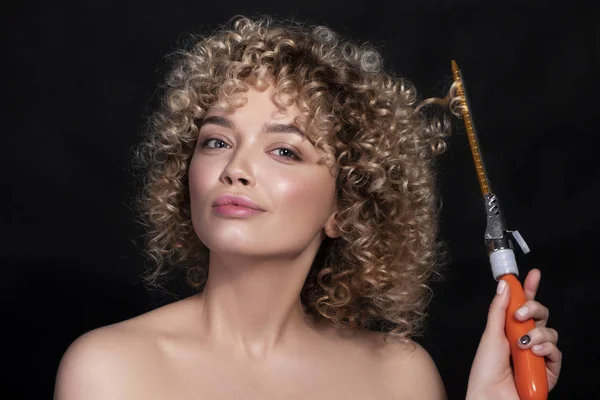 Niedliche kaukasische Frau mit Afro-Frisur (Locken) auf dunklem Rücken — Stockfoto