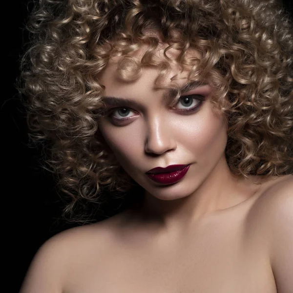 Cute caucasian woman with afro (curls) hairstyle on a dark backg — Stock Photo, Image