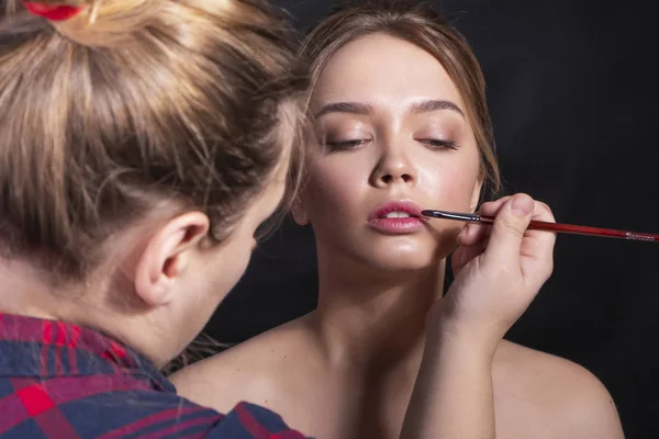 Schattige Kaukasische vrouw met dagelijks kapsel op een donkere achtergrond. — Stockfoto