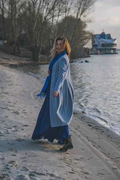 Πανέμορφη Ευρωπαϊκή γυναίκα με ζεστό παλτό και φόρεμα σε μια βόλτα στο πάρκο — Φωτογραφία Αρχείου