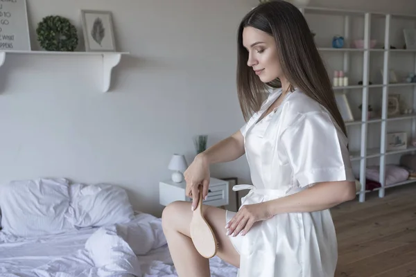 Vacker passar brunett kvinna hemma i pyjamas. Hon gör Beauty PR — Stockfoto