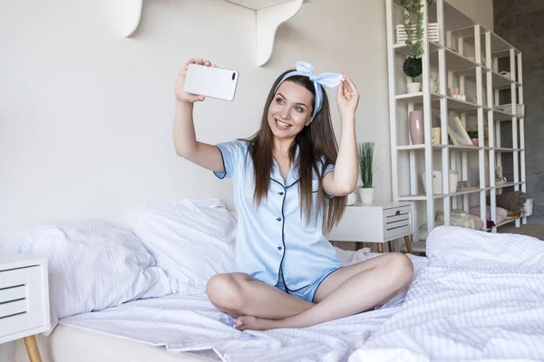 Mooie pasvorm brunette vrouw thuis in pyjama. Ze maken selfie — Stockfoto