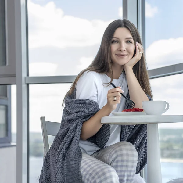 Brunette cheerful woman relaxing at home. She sitting on a chair