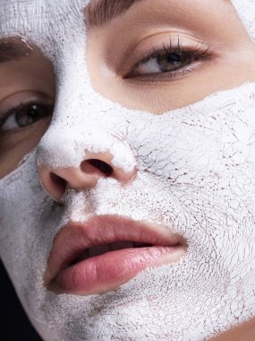 Güzel genç Avrupalı kadın yüzüne kilden maske takıyor. Beau.