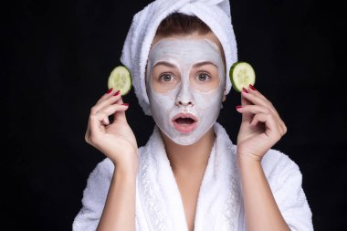 Güzel genç Avrupalı kadın yüzüne kilden bir maske takıyor. 