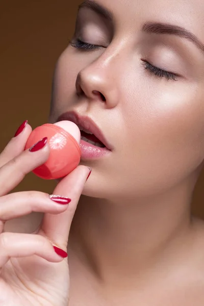 Brünette europäerin auftragen lippenstift auf ihre lippen auf rosa neutral — Stockfoto