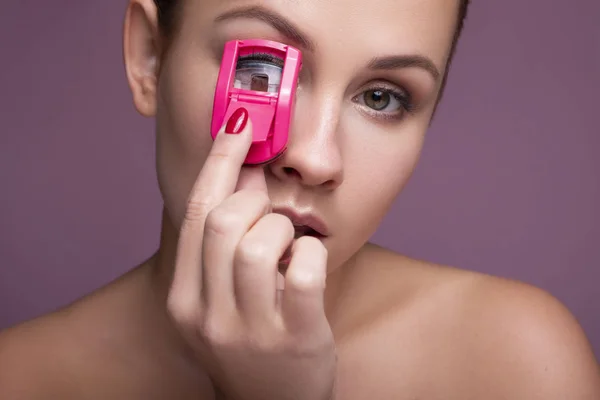 Brunette caucasian woman curve her eyelashes with a tool. Flawle — Stockfoto