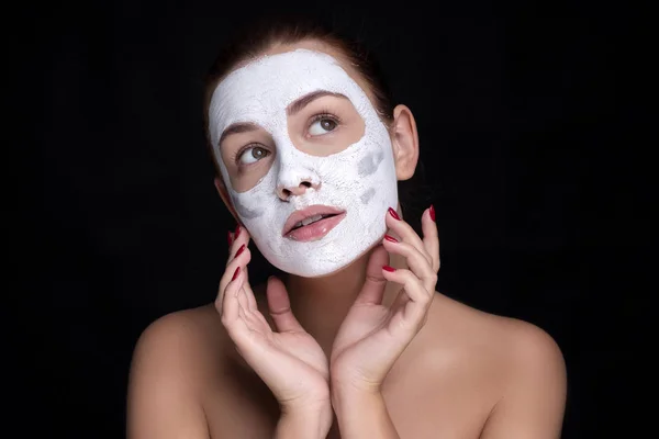 아름다운 유럽 여성 이 얼굴에 찰흙 마스크를 쓰고 있습니다. 보루 — 스톡 사진
