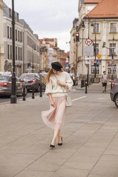 Aranyos, vidám fehér nő sétál az európai utcán. Ő mi... — Stock Fotó