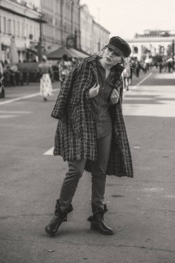 Yaşlı, beyaz bir kadın Avrupa caddesinde yürüyüş yapıyor. Sonbahar