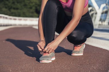 Beyaz tenli, açık havada spor yapan esmer bir kadın.