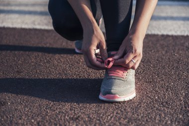 Beyaz tenli, açık havada spor yapan esmer bir kadın.