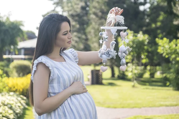 Culla mobile - giocattoli per bambini, vicino alla pancia delle mamme. Natura verde su un — Foto Stock