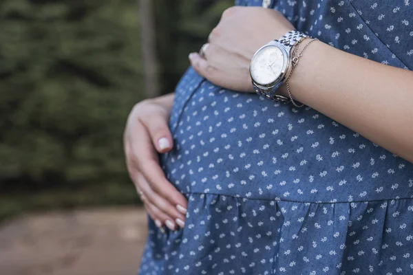 Watch on future mother belly. Outdoor, summer day — Stock Photo, Image