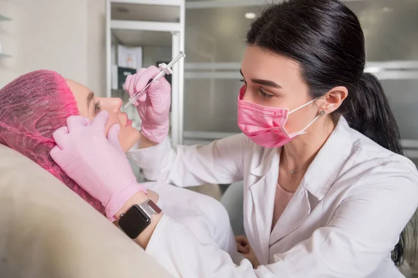 Médico Cosmetólogo Inyecta Una Clienta Clínica Ella Usa Máscara Guantes —  Fotos de Stock