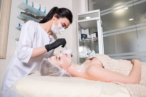 Lekarz Kosmetolog Wykonuje Zabieg Enzymatyczny Kobiecie Klinice Nosi Świecące Maski — Zdjęcie stockowe