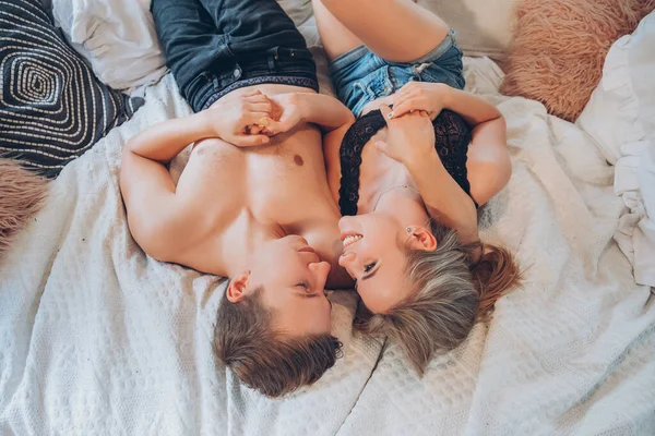 年轻夫妇互相爱抚 他们彼此关心 用爱心拥抱对方 穿着休闲装躺在床上的夏季肖像 — 图库照片