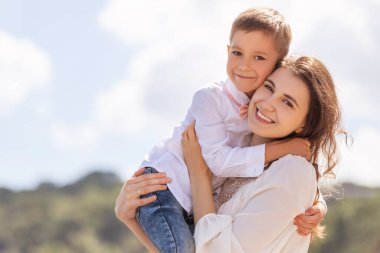 Oğluyla birlikte Avrupa 'da yürüyüş yapan neşeli bir anne. Küçük çocuk gülümsüyor ve eğleniyor. Metin için boşluğu olan yaz portresi.