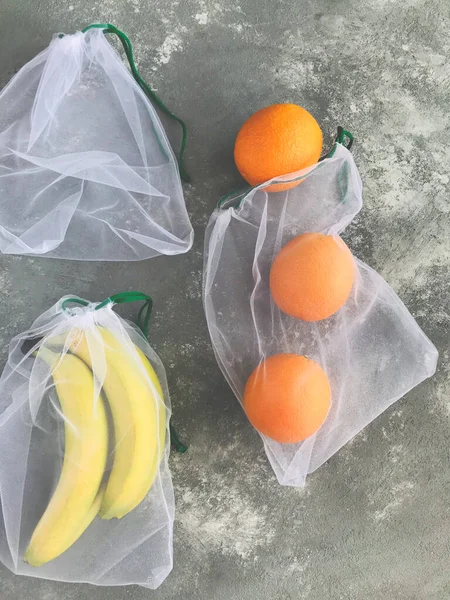 reusable fabric bags and fruits are on the table