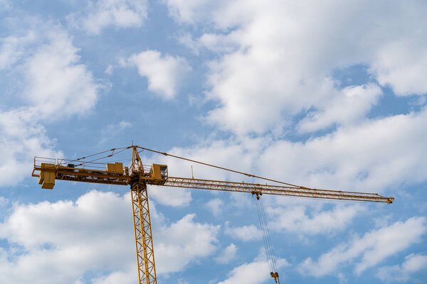 Yellow construction crane on sky background