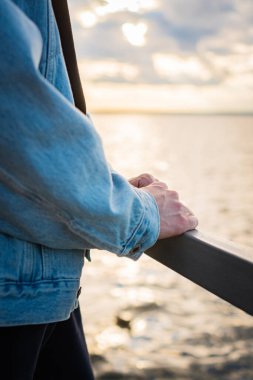 Erkek elleri metal bir tırabzanda yatıyor.