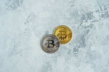 Beyaz arka planda bir masada iki bitcoin Monte
