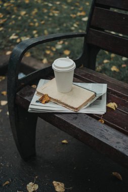 Parktaki bankta bir gazete ve bir bardak kahve var. Moskova Izmaylovsky Park, 2020 sonbaharında.