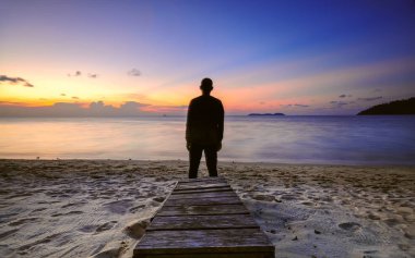 Güzel gündoğumu okyanus manzaralı yalnız insanlar..