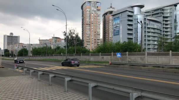 4K. Vue de la circulation automobile près du complexe résidentiel Rivière Riverside. Trafic de voitures dans la rue. Journée nuageuse d'été. Kiev, Ukraine. — Video