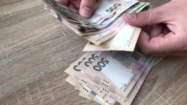 Zbliżenie męskich rąk liczących duże sumy pieniędzy ręcznie w gotówce. Licząc banknoty 500 ukraińskich hrywien. Koncepcja inwestycji, sukcesu, perspektyw finansowych lub rozwoju kariery. 4K. — Wideo stockowe