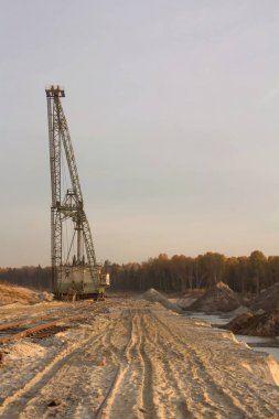 Kum ocağı içinde bir halatlı kazma sistemi Ekskavatör. Fosforit madeni. Kum üzerinde lastik izleri.