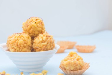 Boondi laddu olarak bilinen popüler Hint yemeği mavi arka planda yer alır..