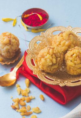 Boondi laddu olarak bilinen popüler Hint yemeği mavi arka planda yer alır..