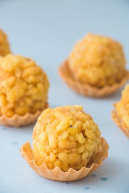 Boondi laddu olarak bilinen popüler Hint yemeği mavi arka planda yer alır..