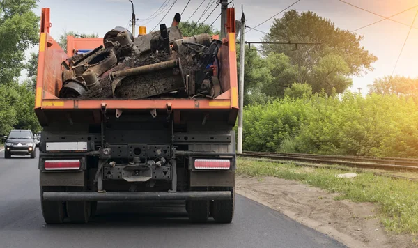 Hurda metal yüklü bir çöp kamyonunun arka görüntüsü.