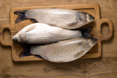 Mutfak tahtasındaki taze sazan balığı..
