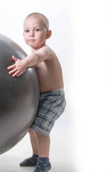 Lindo chico juega con una gran pelota para la aptitud —  Fotos de Stock