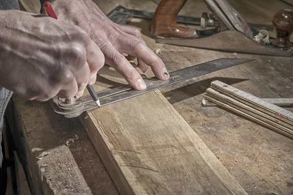 Tischler markiert Maße auf Holzbrett — Stockfoto