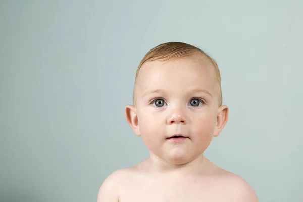 Portret van een baby. Een jongen met blauwe ogen en blond haar. — Stockfoto