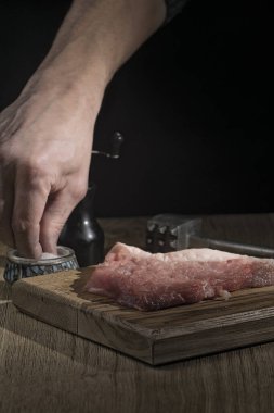Kesme tahtasındaki taze et biftekleri bıçak ve çekiçle.