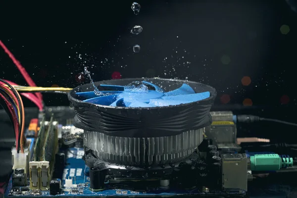 Reinigung der Computer-Hauptplatine ist ein Wasserstrahl auf einem laufenden Ventilator — Stockbild Säuberung der mütterlichen - das Motherboard ist ein Wasserstrahl auf dem laufenden Ventilator — Stockfoto