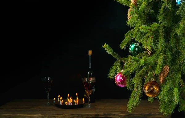Kerst dennenboom met kegels versierd met multi-gekleurde glazen ballen op een zwarte achtergrond — Stockfoto