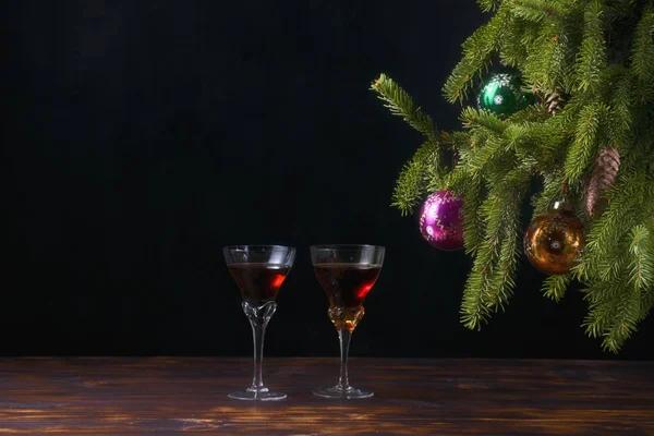 Siyah arka planda çok renkli cam toplarla süslenmiş kozalaklı Noel ağacı